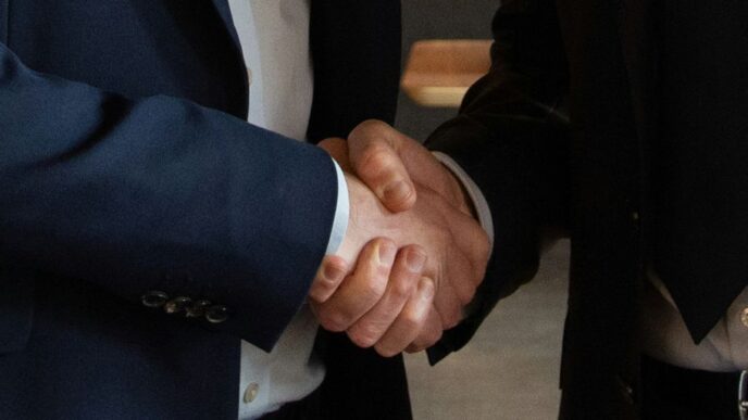 Business partners shake hands, making a deal.