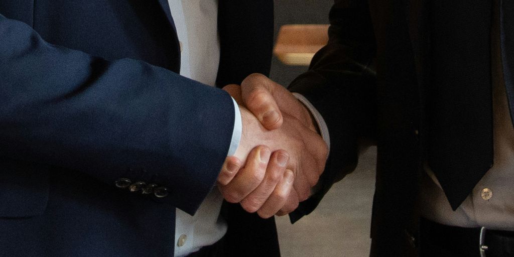 Business partners shake hands, making a deal.