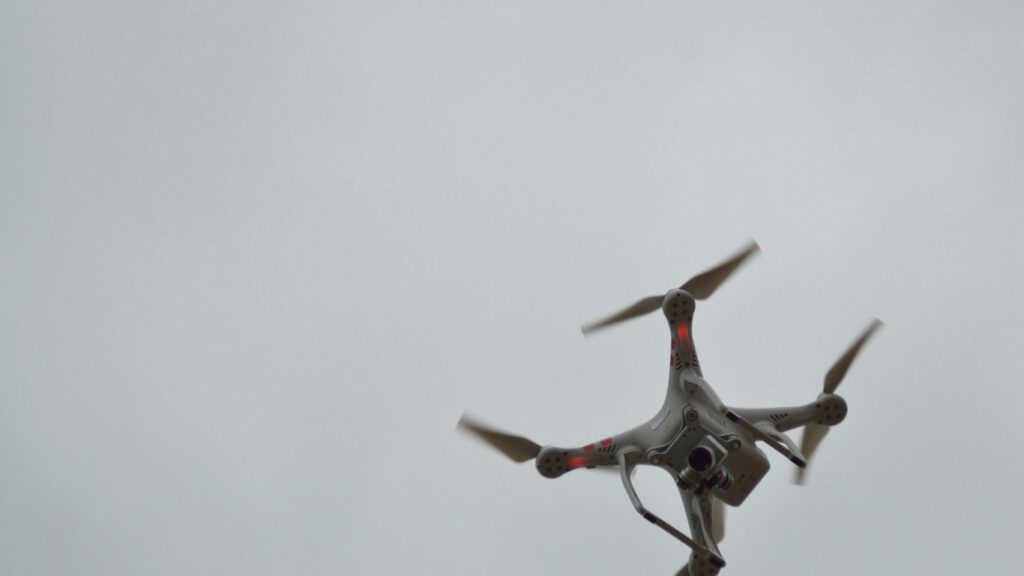 A drone is flying in the cloudy sky.