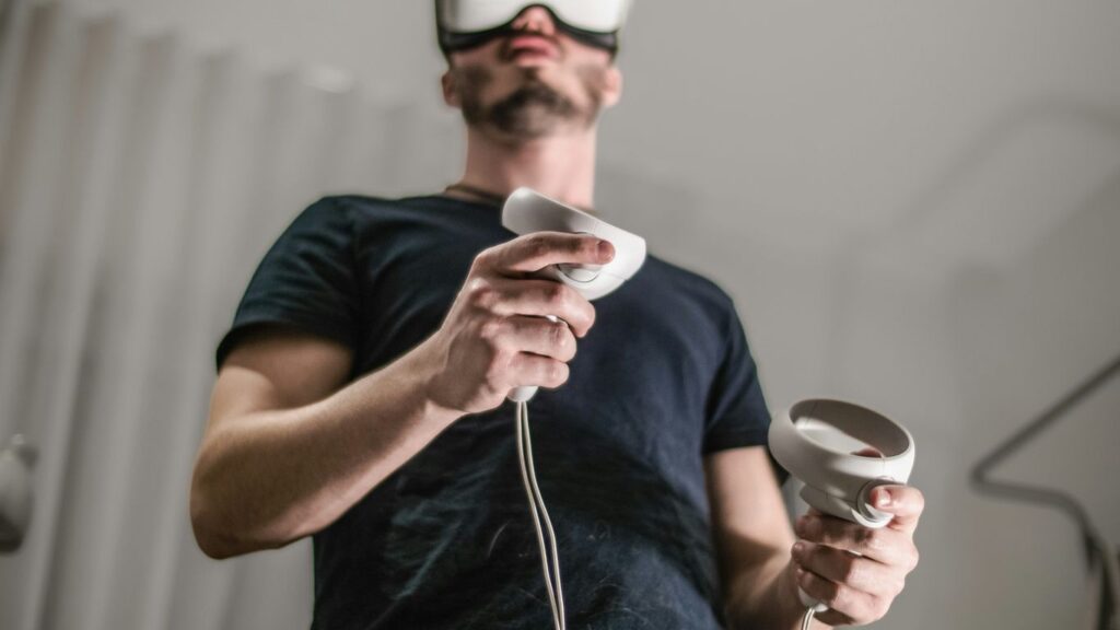 a man wearing a virtual reality headset holding a wii controller