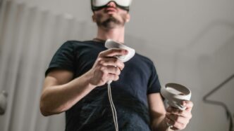 a man wearing a virtual reality headset holding a wii controller