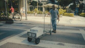 a man pushing a cart across a street
