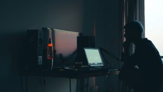 a man sitting in front of a computer in a dark room