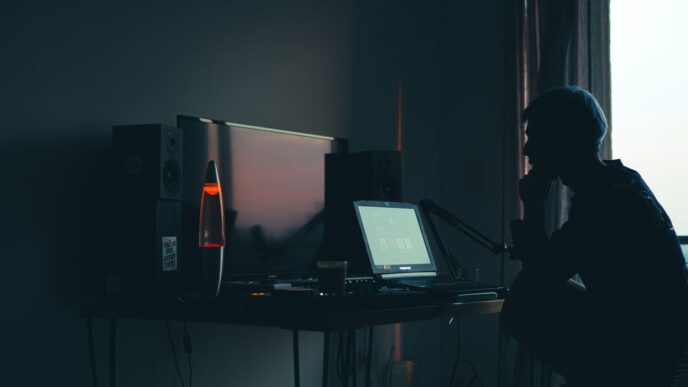 a man sitting in front of a computer in a dark room