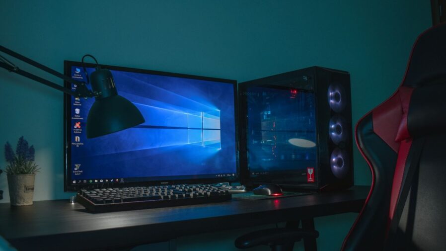 turned on desktop computer set with black and gray leather gaming chair
