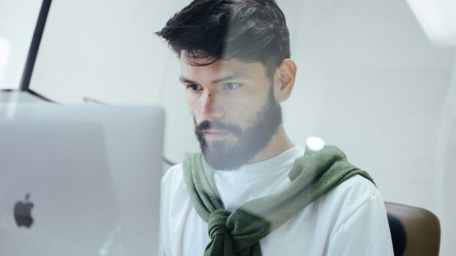 man facing MacBook Pro