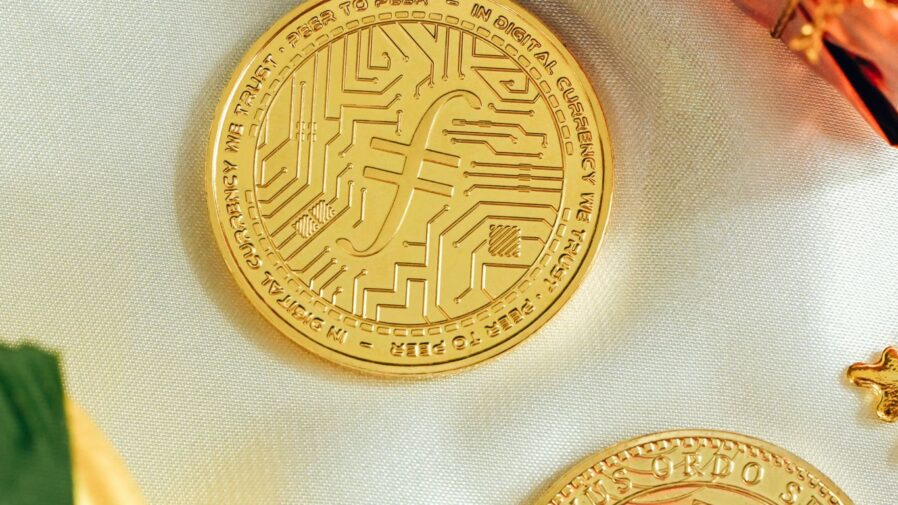 two gold coins sitting on top of a white cloth
