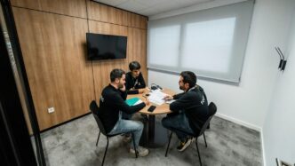 Three people are meeting in a conference room.