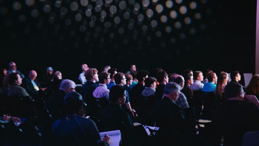 crowd of people sitting on chairs inside room