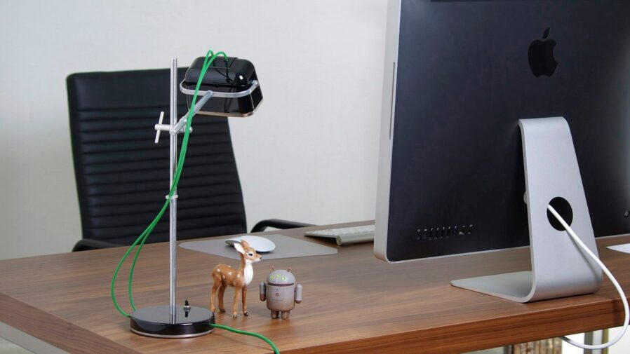 a desk with a computer and a toy horse on it