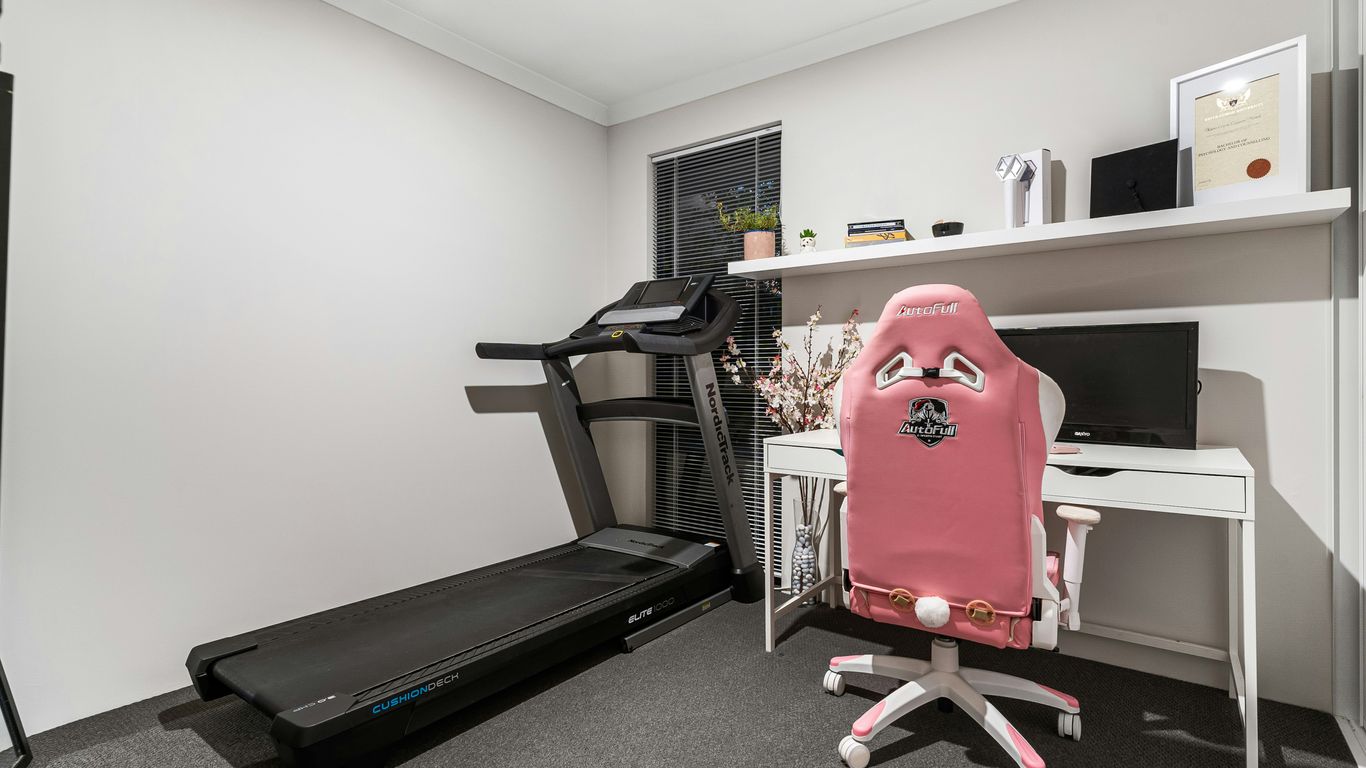 A room with a treadmill and a desk