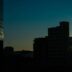 Sunburst over city buildings at dusk