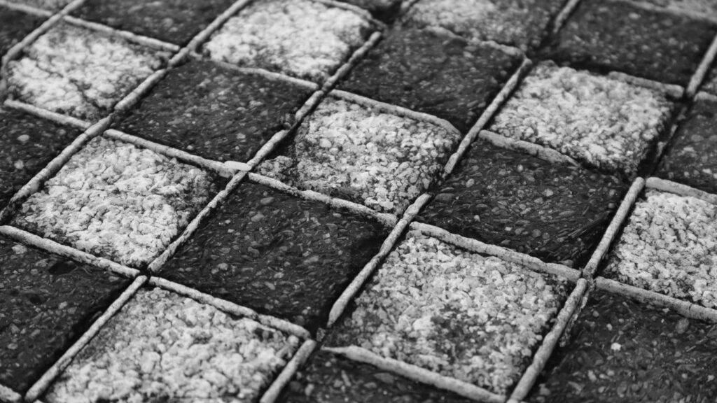 a black and white photo of a cobblestone road