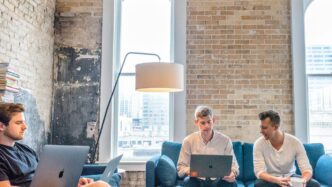 three men using MacBooks