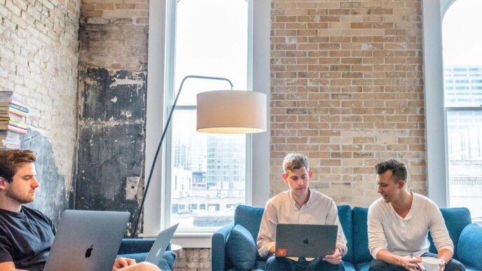 three men using MacBooks