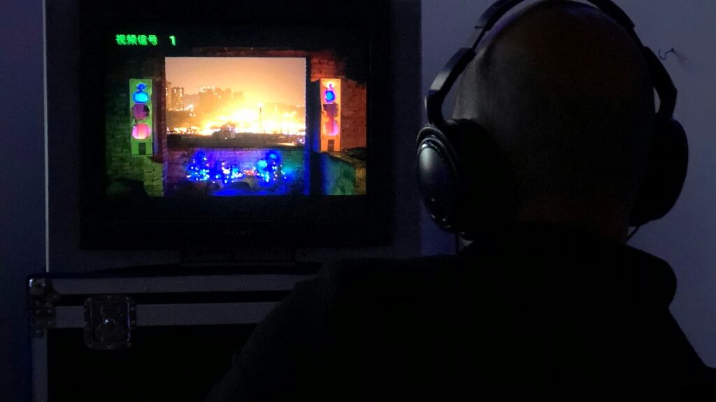 a man sitting in front of a tv with headphones on