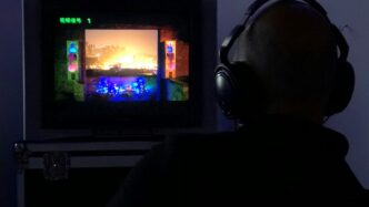 a man sitting in front of a tv with headphones on