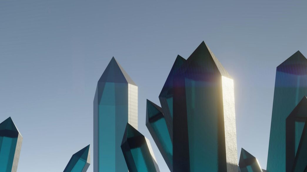 A group of blue glass sculptures in front of a blue sky