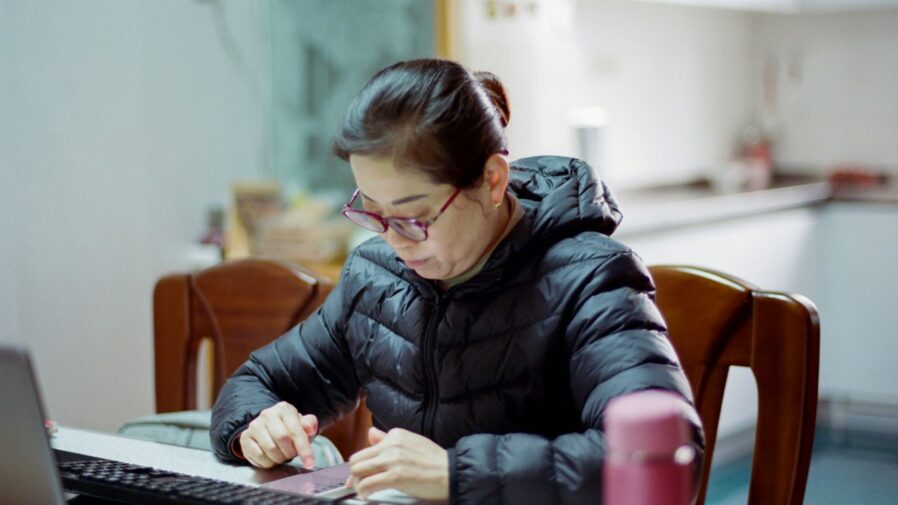 A woman sitting at a table working on a laptop