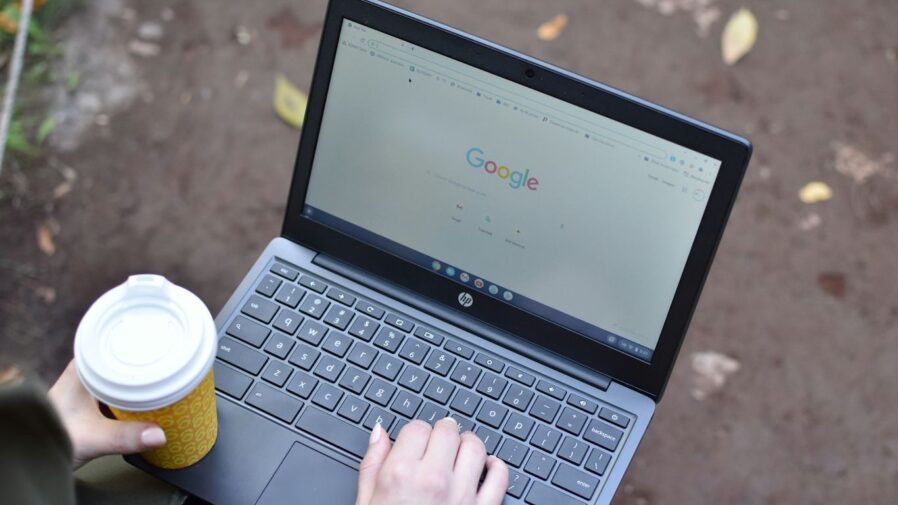 a person using a laptop computer with a cup of coffee