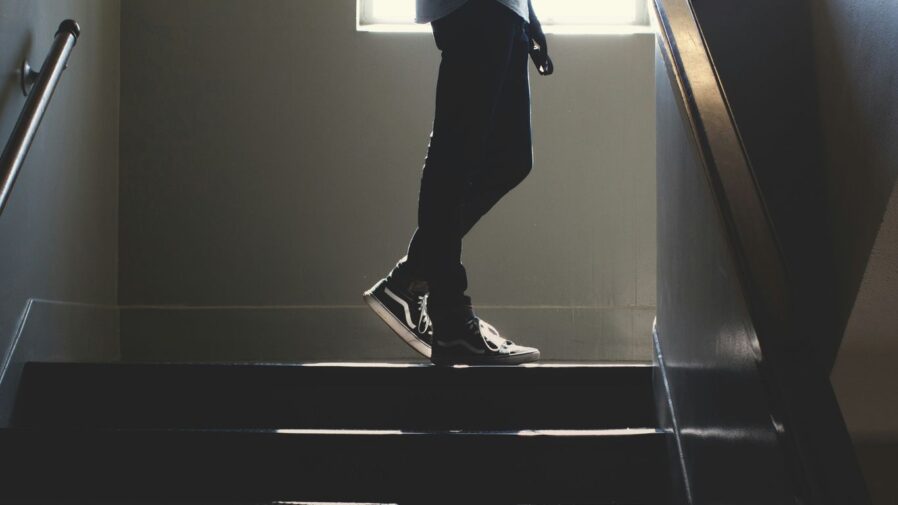 person standing on in a dim-lit stair