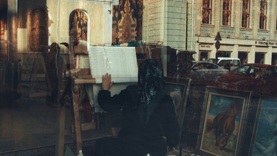 a woman sitting on a chair in front of a painting