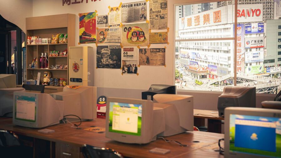 There are many computers on the desks in this room