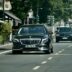 A man walking across a street next to a car