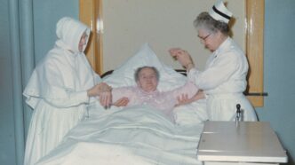 a woman in a hospital bed being assisted by a nurse