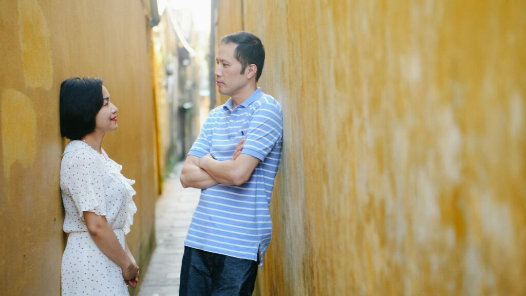a man and a woman standing next to a wall