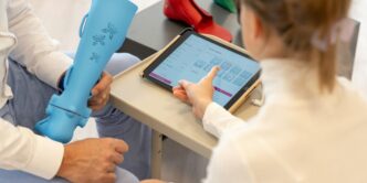 a woman sitting on a table using a tablet