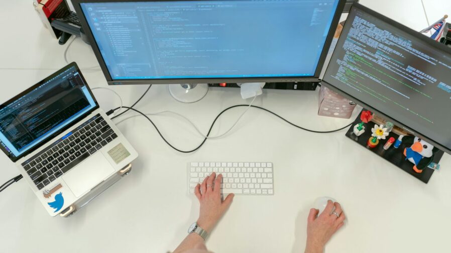 person using macbook pro on white table