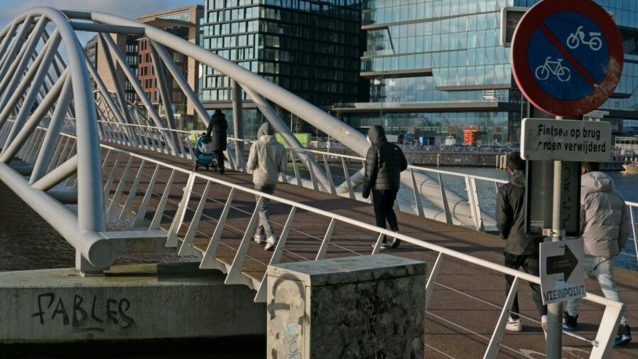a group of people walking across a bridge