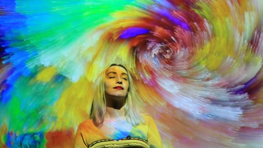 a woman standing in front of a colorful background