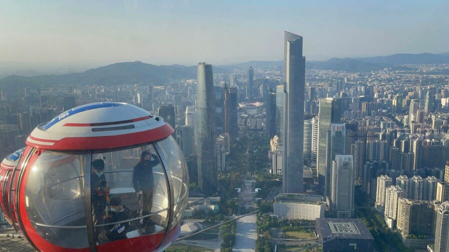 a group of people on a cable car above a city