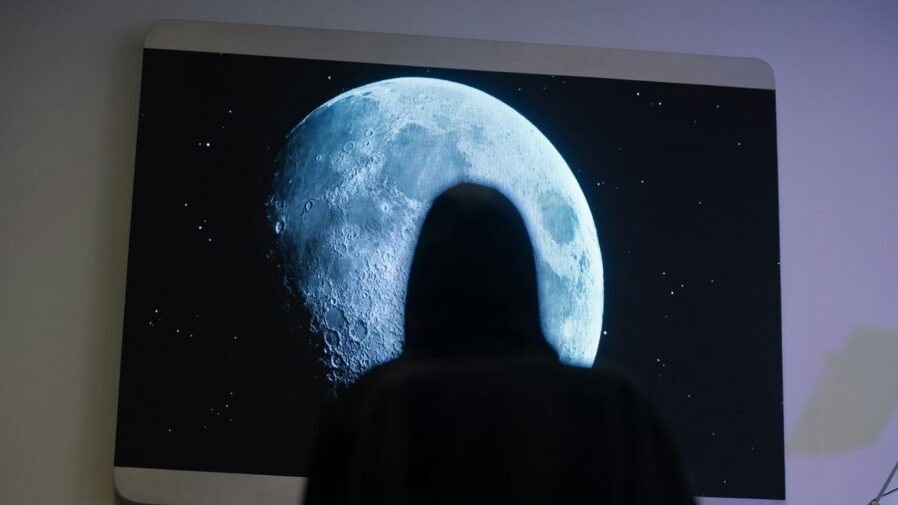 a person standing in front of a picture of a moon