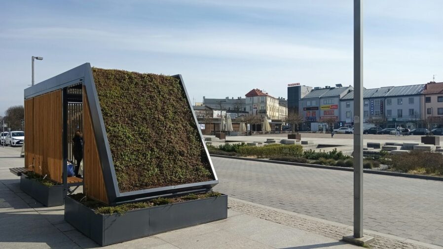 a building with a green roof on the side of it