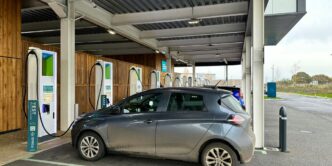 a silver car is parked at a gas station