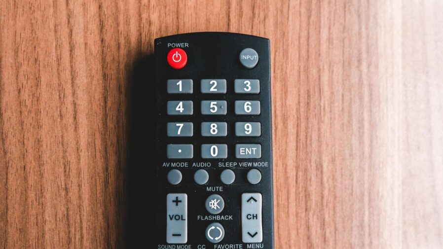 black remote control on brown wooden table