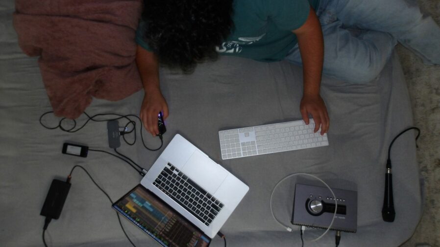 A person laying on a bed with a laptop