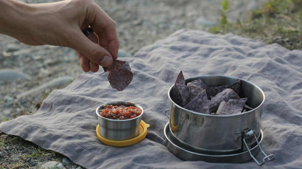 person holding stainless steel bowl with food
