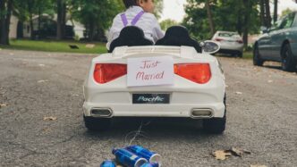 boy riding ride-on car on road