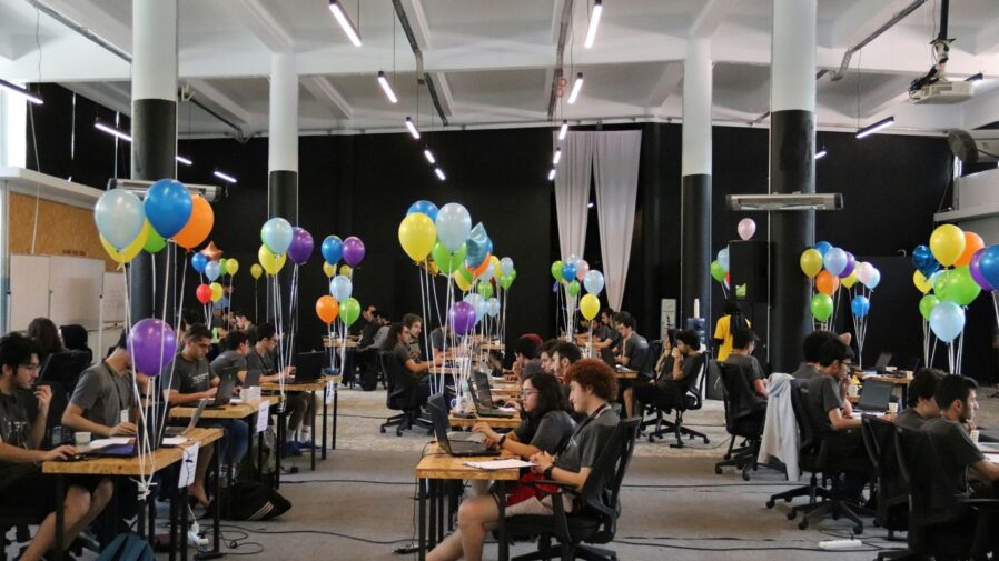 a group of people sitting at desks with balloons