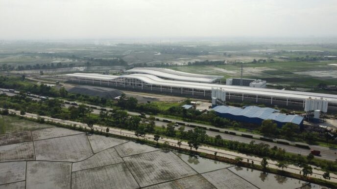 an aerial view of an airport with a large building in the background