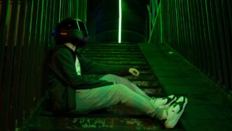 A man wearing a helmet sitting on a ledge