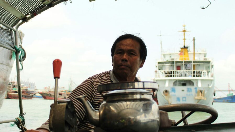 man in black and white striped polo shirt holding stainless steel jar