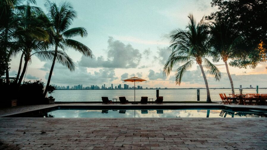 a swimming pool with chairs and an umbrella