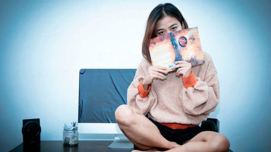 woman in pink sweater holding 20 philippine peso bill