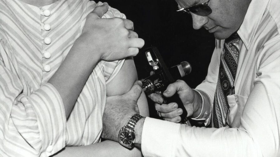 a black and white photo of a man holding a baby