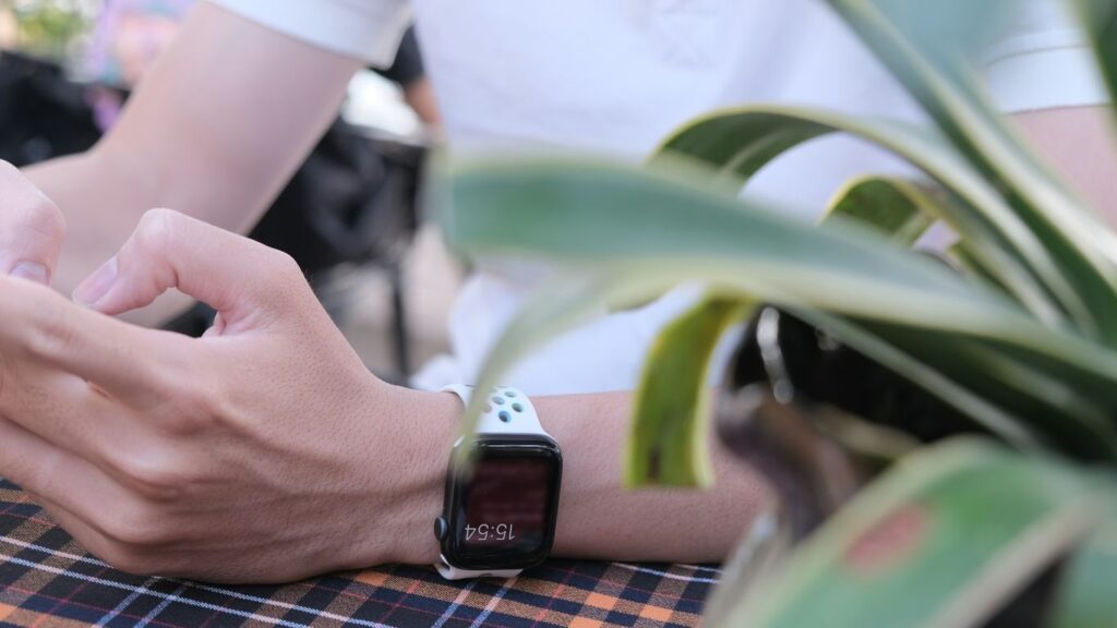 person wearing silver aluminum case apple watch with white sport band